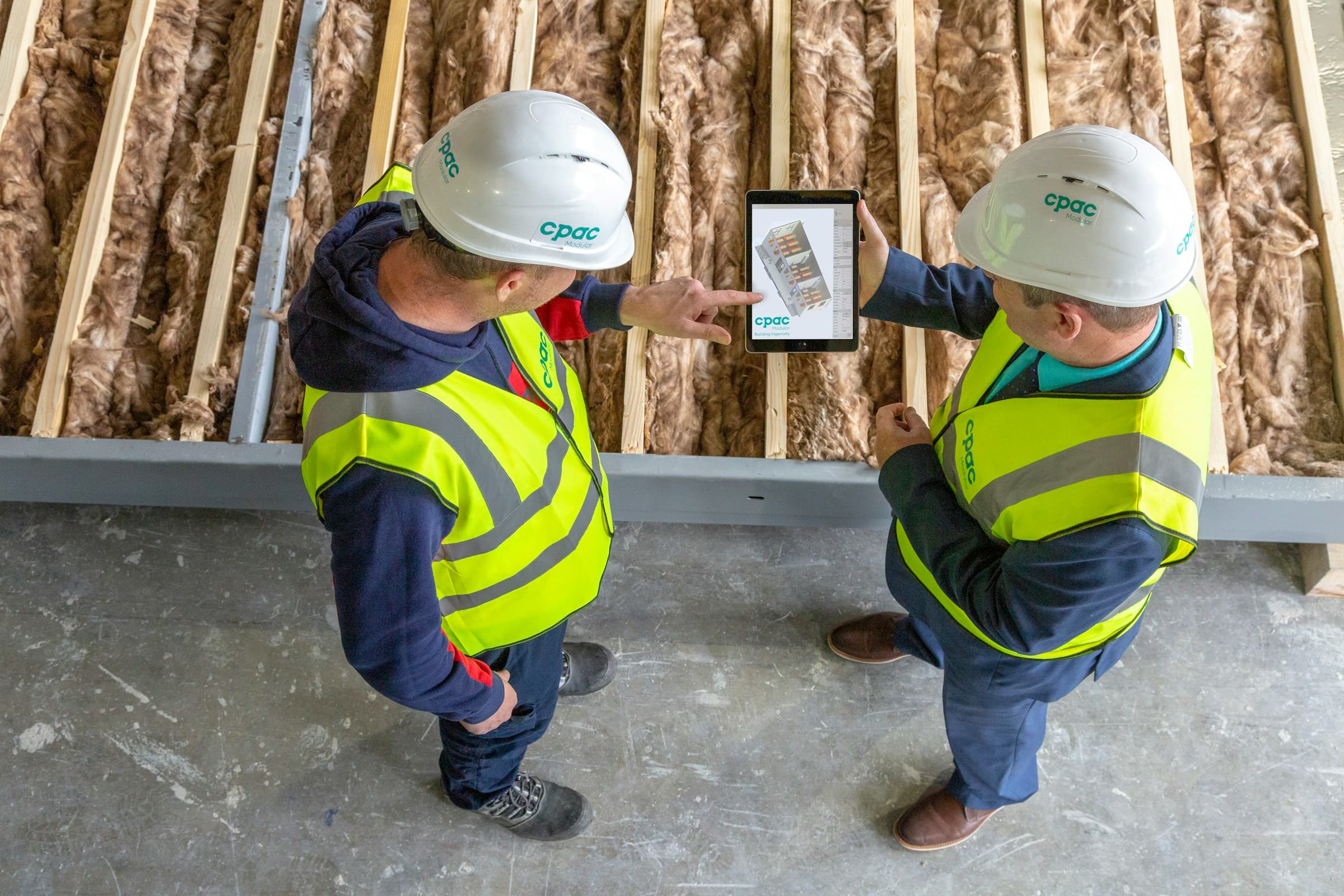 Two engineers reviewing project drawings on a tablet